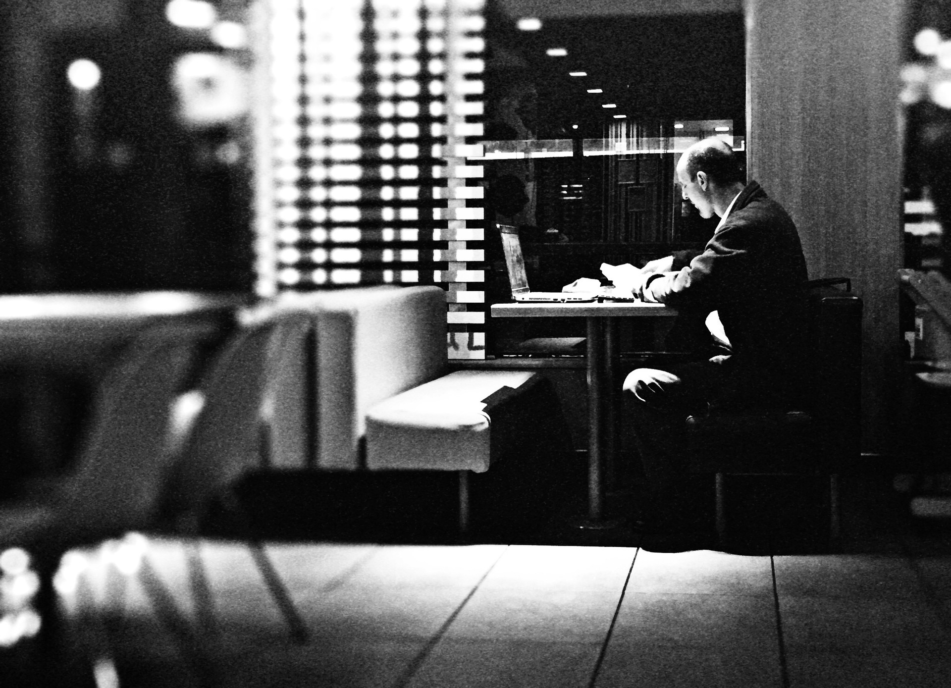 Side View Of Businessman Working On Laptop In Restaurant