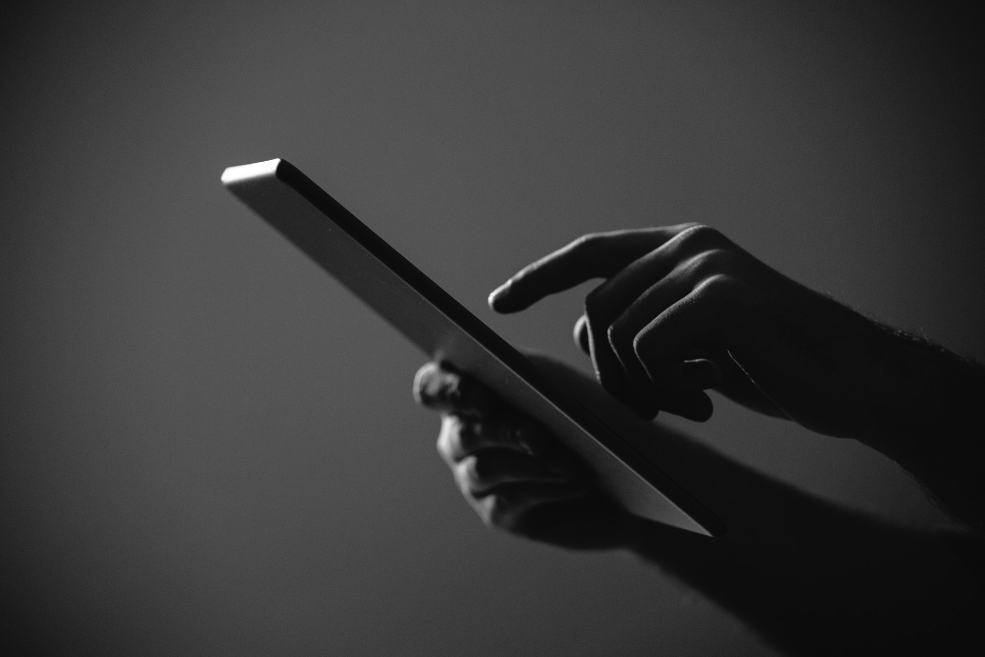 Black and White shot of hands working with Digital tablet